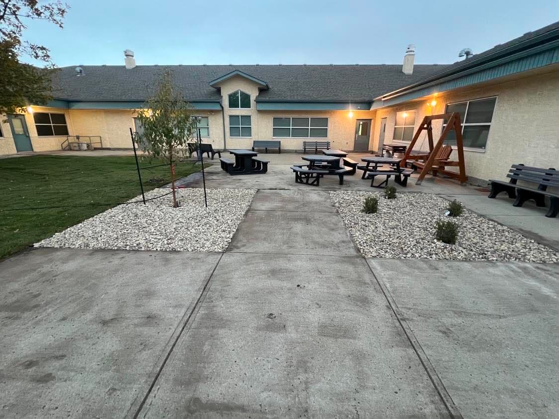 A completed courtyard with new shrub beds, decorative rock and fresh concrete walkways