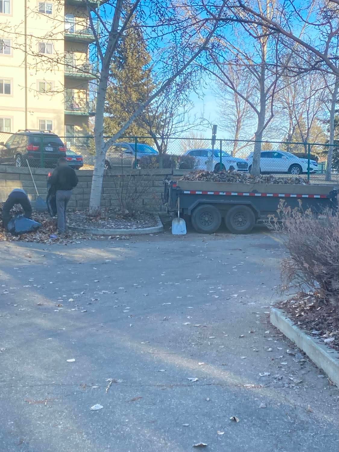 Crew and equipment working a managed apartment property during a seasonal cleanup